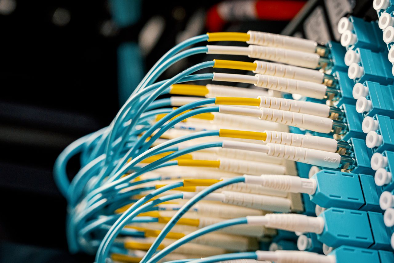 Home High angle of fiber optical switch with connected cables in modern server room